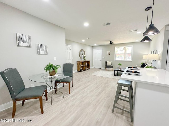 interior space with light wood-type flooring, visible vents, baseboards, and light countertops