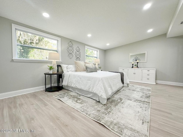 bedroom featuring light wood-style floors, baseboards, a textured ceiling, and recessed lighting