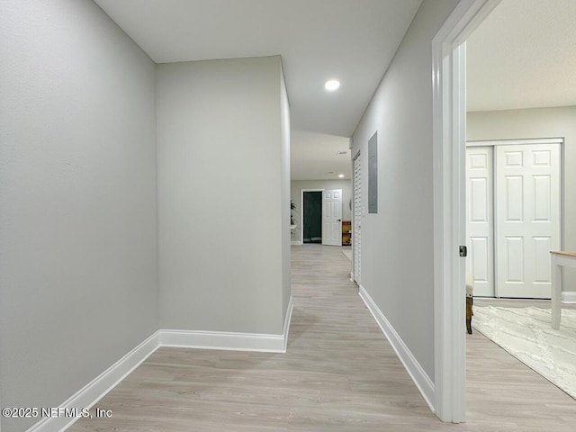 hall featuring recessed lighting, light wood-type flooring, and baseboards