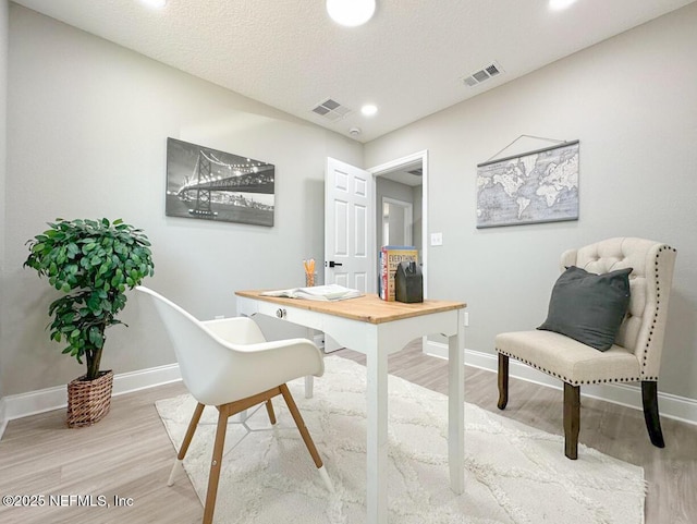 office with wood finished floors, visible vents, and baseboards