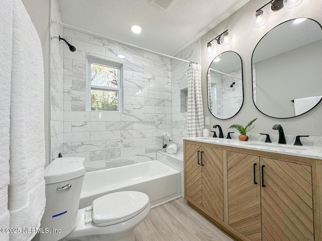 full bathroom featuring shower / tub combo with curtain, a sink, toilet, and wood finished floors