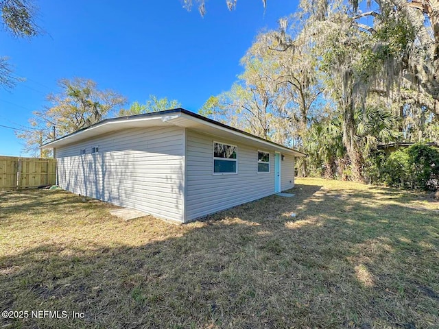 exterior space with fence and a lawn