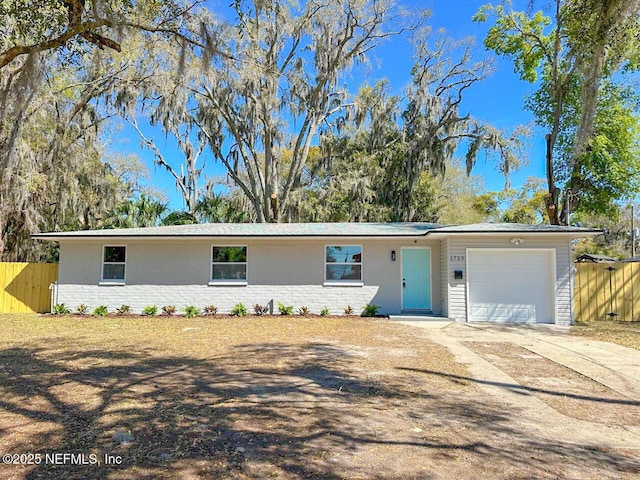 ranch-style house featuring concrete driveway, brick siding, and fence