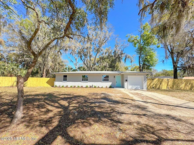 ranch-style house with a garage, driveway, and fence