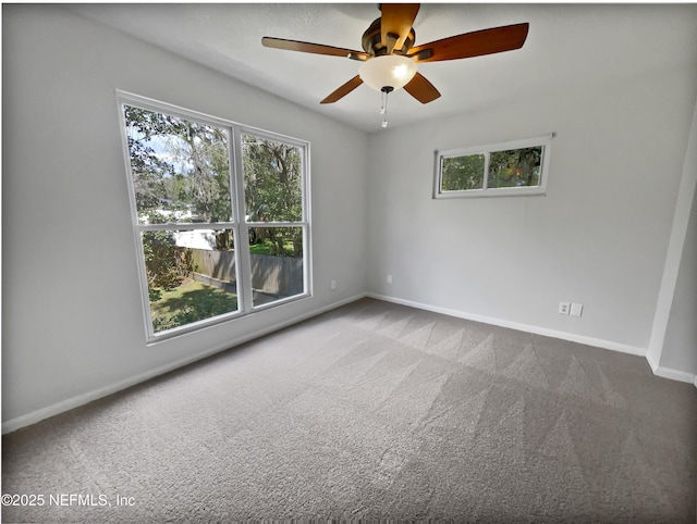 carpeted spare room featuring a ceiling fan and baseboards