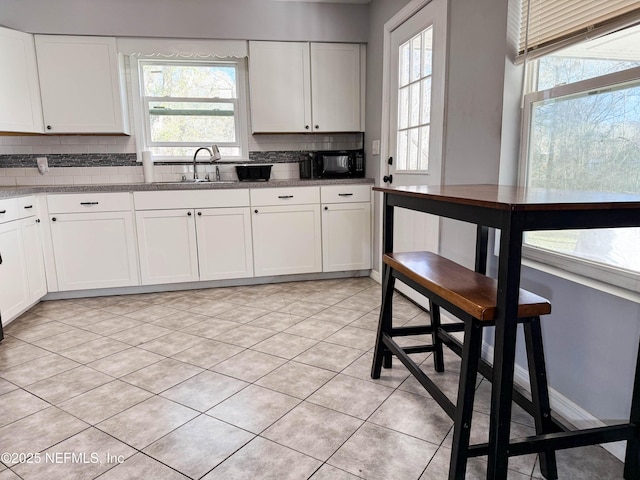 kitchen featuring backsplash, a sink, and white cabinets