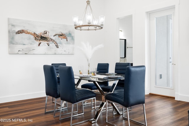 dining room featuring a notable chandelier, baseboards, and wood finished floors