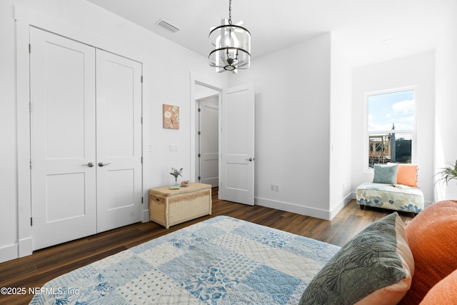 bedroom featuring visible vents, baseboards, a closet, a notable chandelier, and dark wood-style flooring