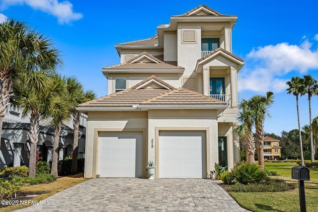 view of front of house with decorative driveway, stucco siding, and a tile roof