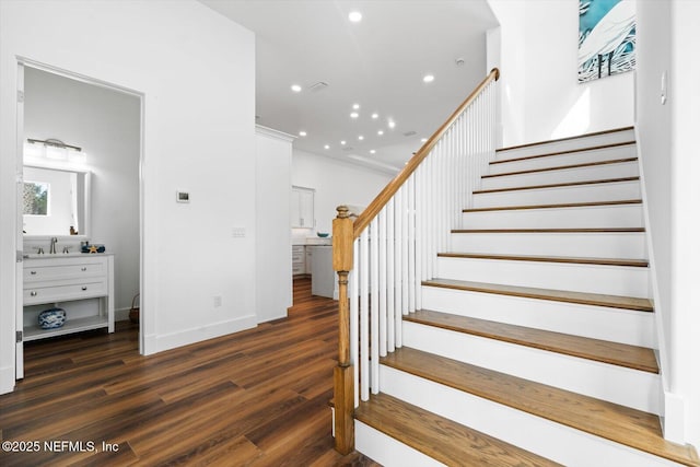 stairway with recessed lighting, baseboards, and wood finished floors