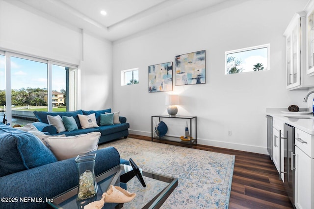 living room with beverage cooler, recessed lighting, dark wood-type flooring, and baseboards