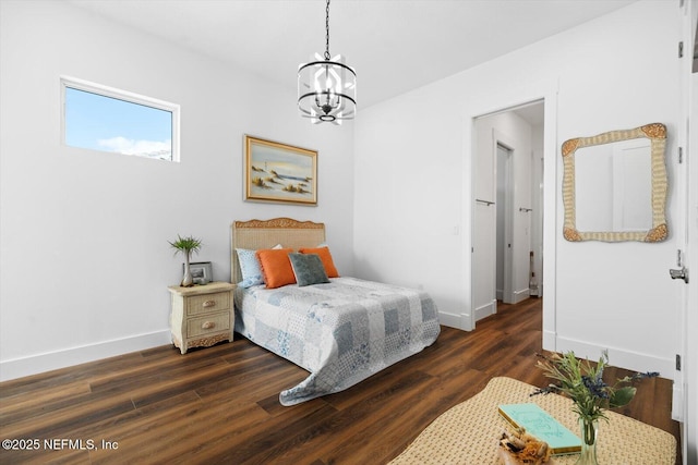 bedroom featuring baseboards, a notable chandelier, and wood finished floors