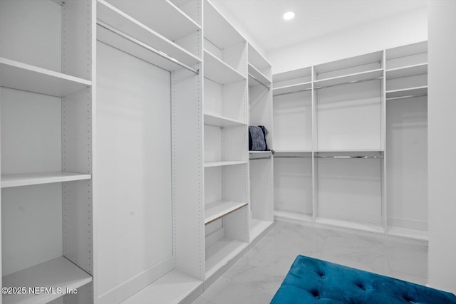 walk in closet with marble finish floor