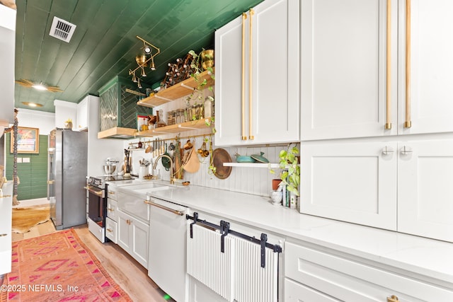 kitchen featuring visible vents, appliances with stainless steel finishes, white cabinets, a sink, and wooden ceiling