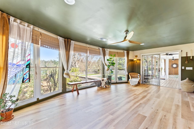 unfurnished sunroom with a ceiling fan and visible vents