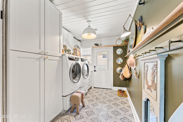 washroom featuring light floors, separate washer and dryer, cabinet space, and baseboards