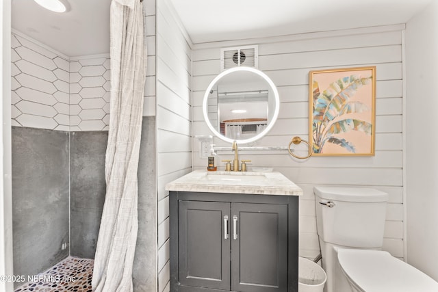 full bathroom featuring visible vents, a tile shower, vanity, and toilet