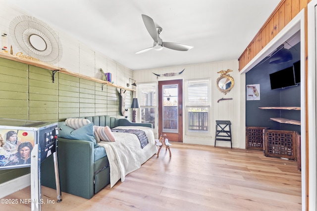 bedroom with access to outside, wood finished floors, and a ceiling fan