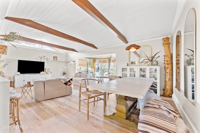 dining space featuring lofted ceiling with beams and light wood-style flooring