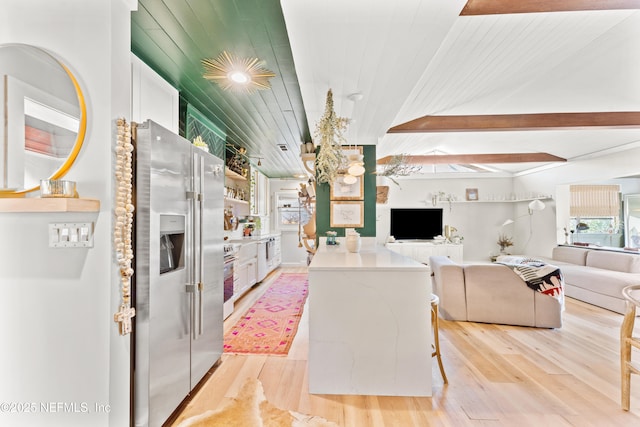 kitchen with open floor plan, light wood-style flooring, and stainless steel fridge with ice dispenser