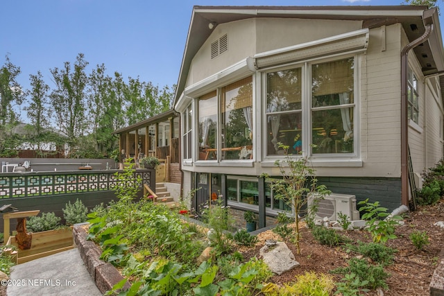 view of side of property with ac unit and a garden