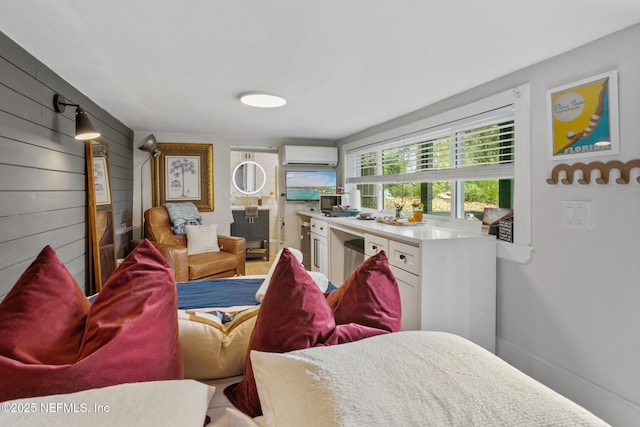 bedroom featuring a wall unit AC and baseboards