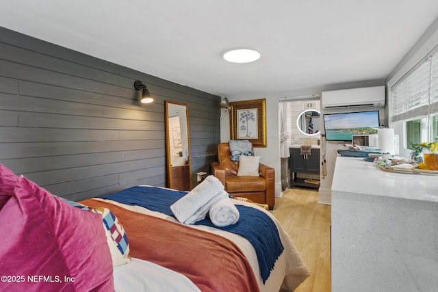 bedroom featuring a wall unit AC, light wood-style floors, and wooden walls