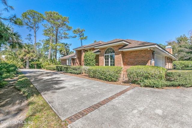 24620 Deer Trace Dr, Ponte Vedra Beach, FL 32082 - view of front of house with an attached garage, brick siding, and a chimney