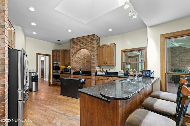 24620 Deer Trace Dr, Ponte Vedra Beach, FL 32082 - kitchen featuring a peninsula, a sink, appliances with stainless steel finishes, a kitchen breakfast bar, and light wood-type flooring