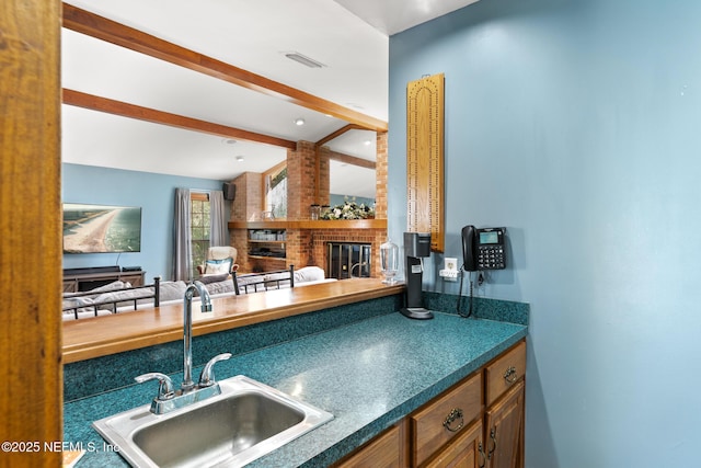 24620 Deer Trace Dr, Ponte Vedra Beach, FL 32082 - kitchen featuring beamed ceiling, visible vents, a sink, open floor plan, and a fireplace