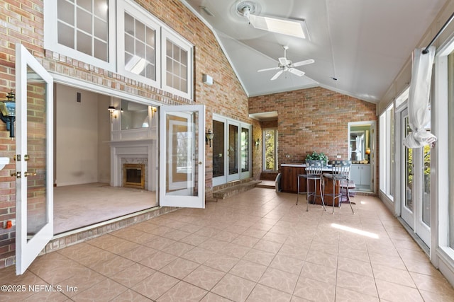 24620 Deer Trace Dr, Ponte Vedra Beach, FL 32082 - unfurnished sunroom with a fireplace, vaulted ceiling with skylight, french doors, and a ceiling fan