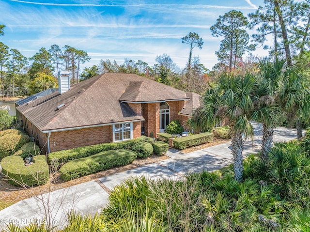 24620 Deer Trace Dr, Ponte Vedra Beach, FL 32082 - view of front of property featuring a shingled roof, brick siding, driveway, and a chimney