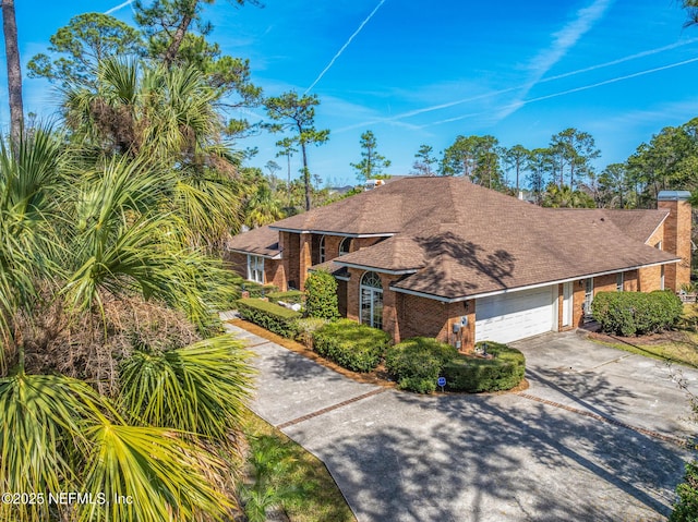 24620 Deer Trace Dr, Ponte Vedra Beach, FL 32082 - view of front facade with an attached garage, brick siding, driveway, and roof with shingles
