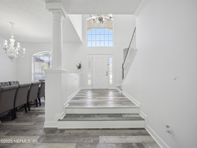 entryway featuring crown molding, stairway, and a notable chandelier