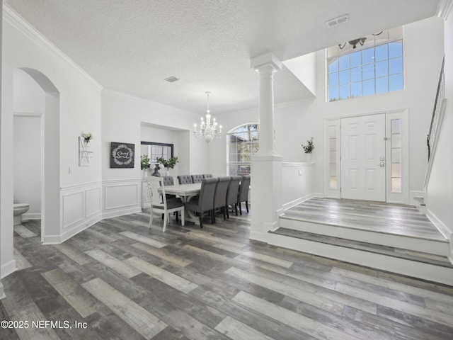 entryway featuring a notable chandelier, visible vents, a textured ceiling, and wood finished floors