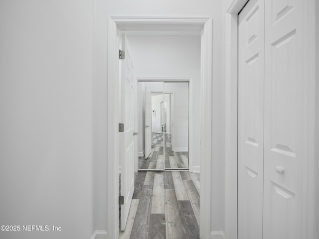 hall featuring wood finished floors and baseboards