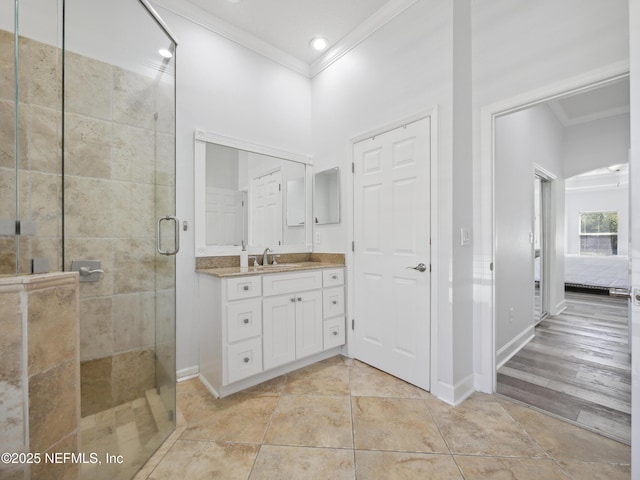 bathroom with vanity, a shower stall, baseboards, and ornamental molding