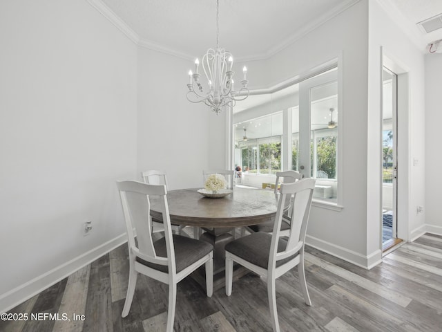 dining space with crown molding, wood finished floors, visible vents, and baseboards