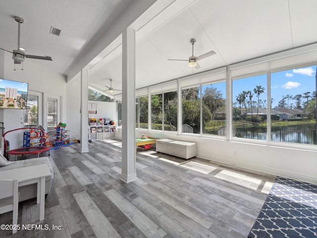 sunroom with visible vents, ceiling fan, and a water view