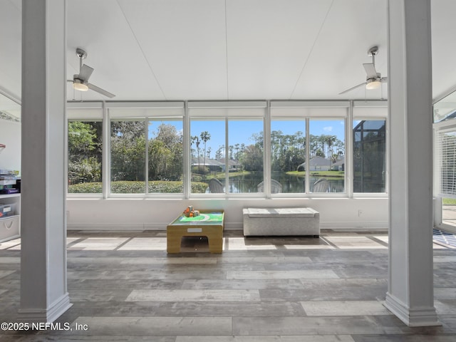 unfurnished sunroom featuring a wealth of natural light, ornate columns, and a ceiling fan