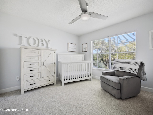 bedroom featuring baseboards, carpet floors, a textured ceiling, and ceiling fan