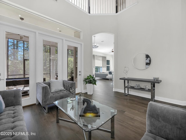 297 S Hampton Club Way, Saint Augustine, FL 32092 - living area featuring a towering ceiling, arched walkways, hardwood / wood-style flooring, and baseboards