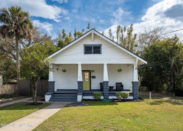 view of front of property with fence, a porch, and a front yard