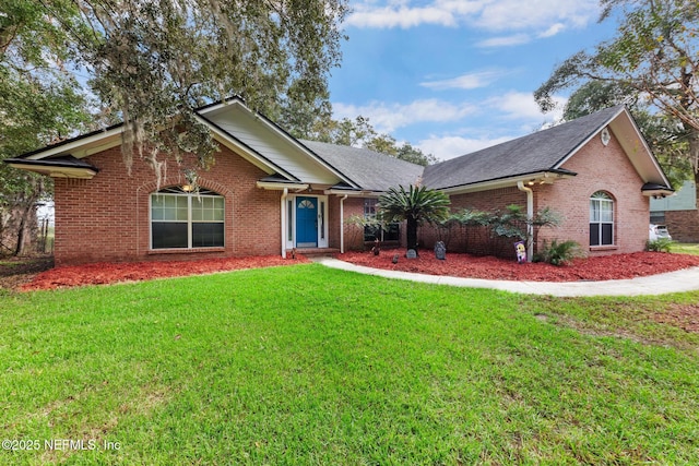 single story home featuring a shingled roof, brick siding, and a front lawn