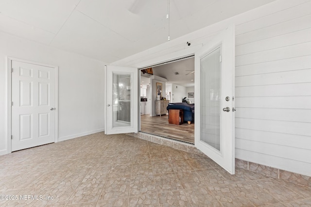 unfurnished room with a ceiling fan and french doors