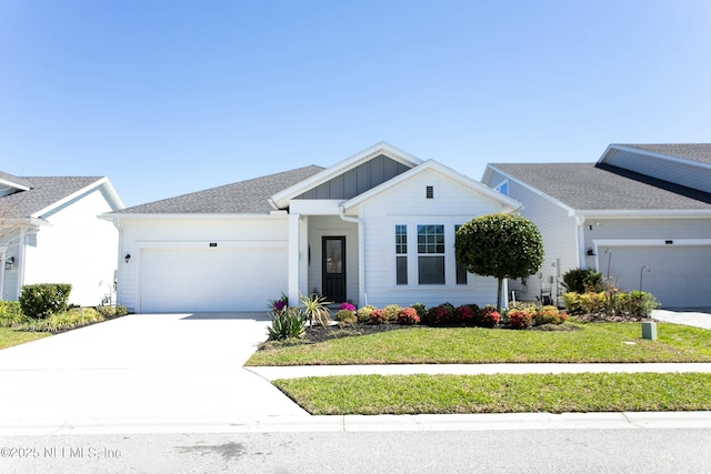 view of front of property with a front yard, an attached garage, board and batten siding, and driveway