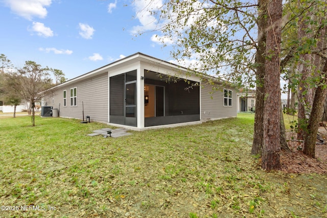 back of house featuring a sunroom and a lawn