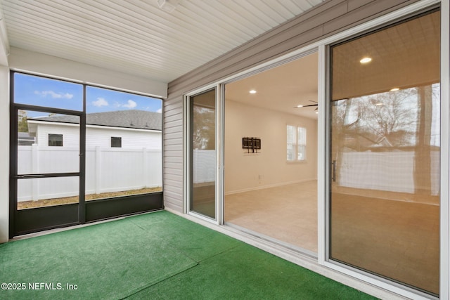 unfurnished sunroom with ceiling fan