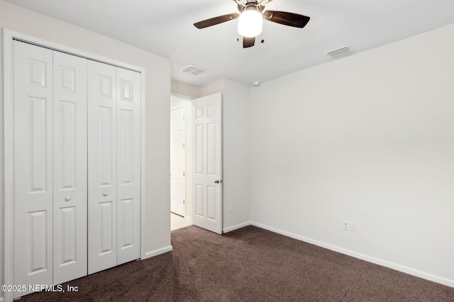 unfurnished bedroom featuring dark colored carpet, a closet, visible vents, and baseboards