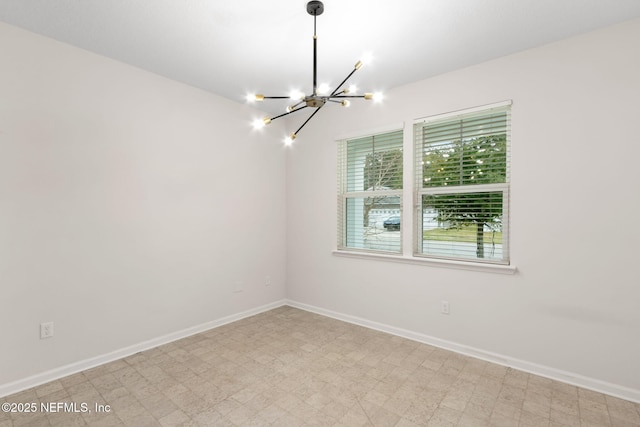 empty room featuring baseboards, light floors, and an inviting chandelier